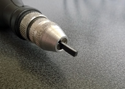 The cut plastic stock mounted in a rotary tool chuck