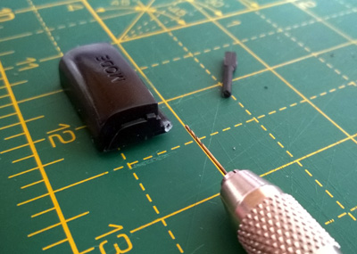 Starting to drill through the plastic part to make a hole to mount the metal pin