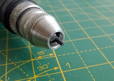 Starting to drill through the plastic peg to make a hole to mount the metal pin