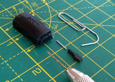 The broken button, plastic peg, and paper clip used to join them